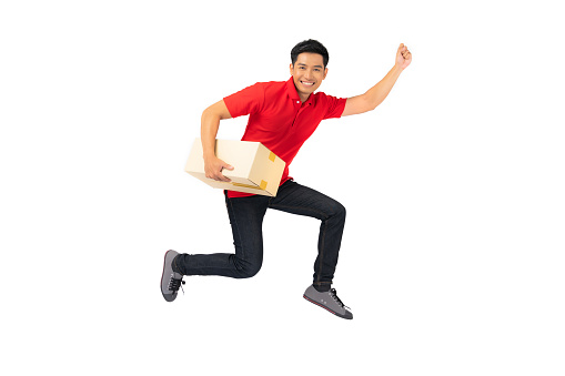 Smiling delivery man employee in blank t-shirt uniform Jumping with parcel post box isolated on white background
