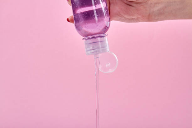 la mujer está vertiendo jabón líquido de la botella. - shower gel fotografías e imágenes de stock