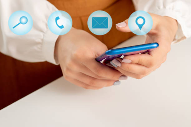 istock Women's hands with a mobile phone and icons for search, call, mail, geolocation. Modern technologies and web concept 1278263596