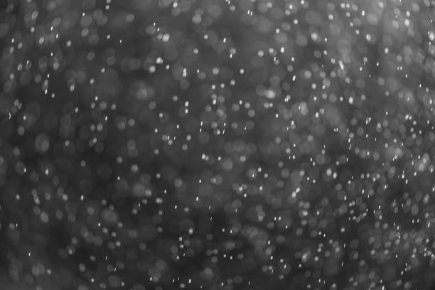 istock snow or rain bokeh texture overlay on black background. 1278267475