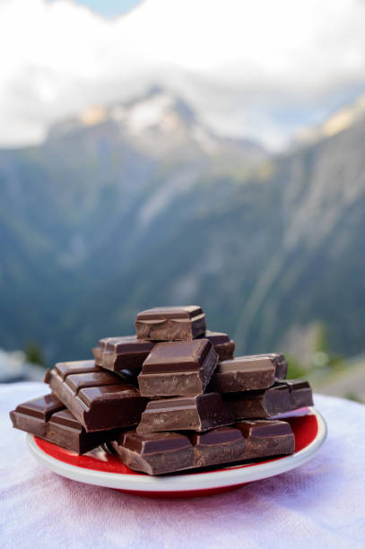 istock Handmade pure dark swiss chocolate and Alpine mountains on background 1278268959
