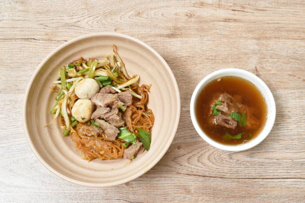 fideos de arroz que alzan cerdo estofado y bola con hueso en sopa de hierbas marrones - stuffing celery onion spoon fotografías e imágenes de stock