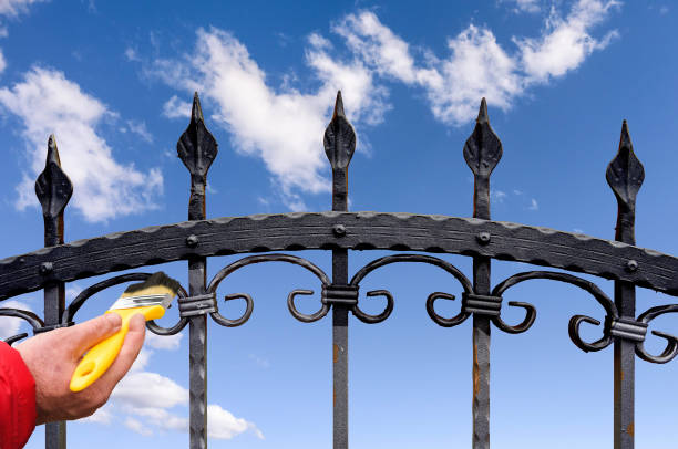 painting fence hand with brush painting wrought iron fence wrought iron stock pictures, royalty-free photos & images