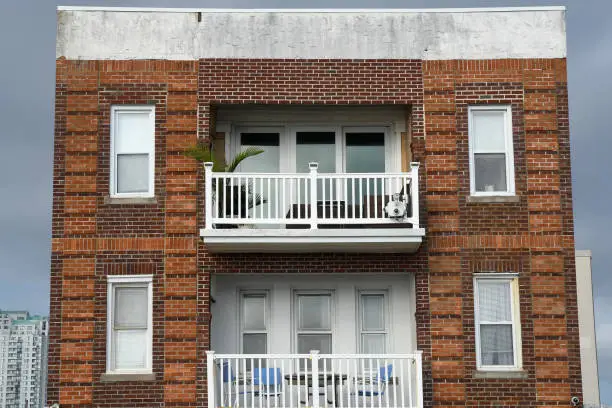 A single and oddly built apartment building faces out directly in front of the Atlantic city boardwalk.