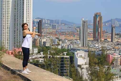 sporty woman take exercise in front of the skyline of city
