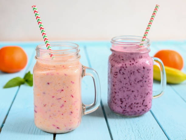 koktajl jagodowy z miętą w słoiku mason ze słomą na tle drewna - blueberry smoothie glass striped zdjęcia i obrazy z banku zdjęć