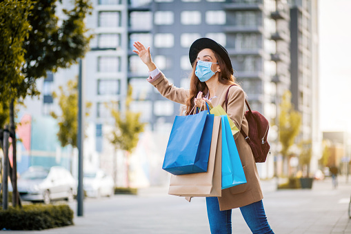 Mujer joven con hacer máscara después de ir de compras esperando impuestos photo
