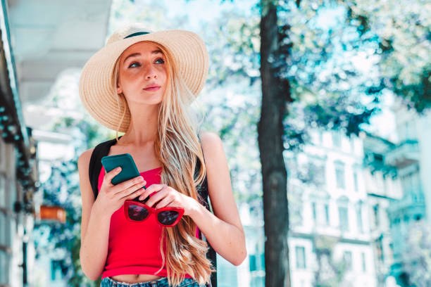 istock Young woman text messaging while standing on the street 1278285621
