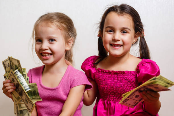 istock two little girls with dollars on white background 1278285849