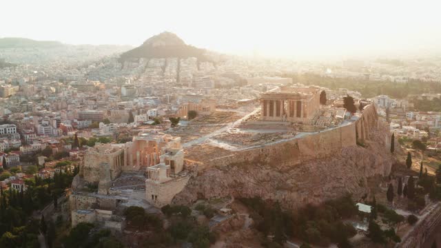 Acropolis city of Athens parthenon, symbol of ancient Greece, aerial view slide from drone on panorama of residential buildings at sunrise summer. Lights sun, lens flare. World Heritage sites. History