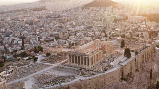Acropolis city of Athens parthenon, symbol of ancient Greece, aerial view slide from drone on panorama of residential buildings at sunrise summer. Lights sun, lens flare. World Heritage sites. History