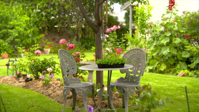 Outdoor table and chairs in a beautiful landscaped backyard garden park