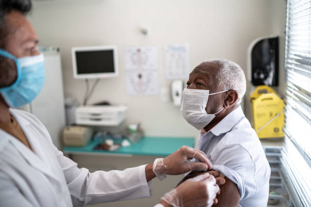 istock Nurse applying vaccine on patient's arm using face mask 1278287283