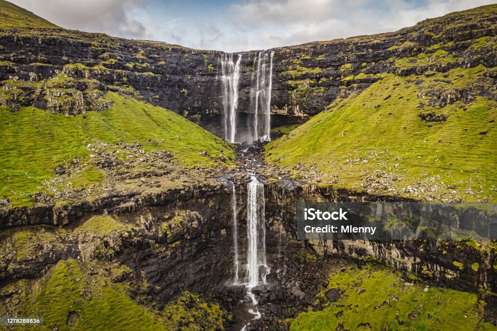 Faroe Islands Fossá Waterfall Fossa Streymoy Island Aerial View Streymoy Island on the Faroe Islands famous Fossa Waterfall, the tallest waterfall on the Faroe Islands. Aerial drone point if view down to both stages of the waterfall as It's falling and cascading 140 meters down to the North Atlantic Ocean Fjord in two stages from the top. Fossa - Fossá Waterfall, Haldórsvík, Streymoy Island, Faroe Islands, Kingdom of Denmark, Nordic Countries, Europe Faroe Islands Stock Photo