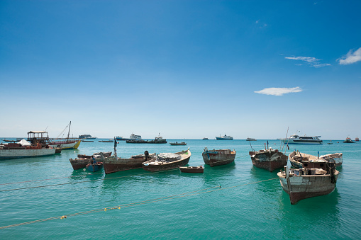 Stone Town, Zanzibar, Tanzania | October 21, 2007: Boats and people in the turquoise sea at the harbour