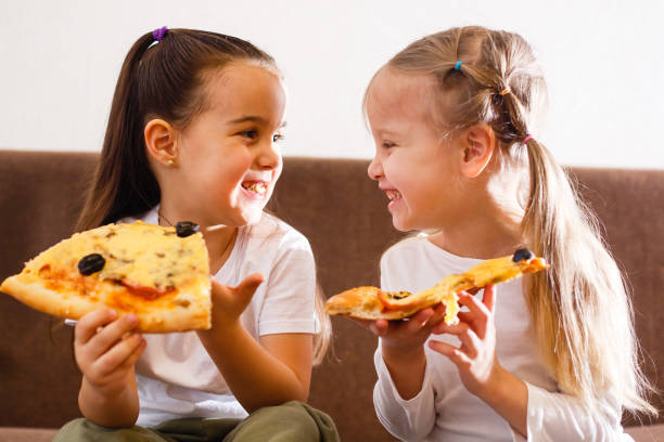 istock Young girls eating pizza 1278289704