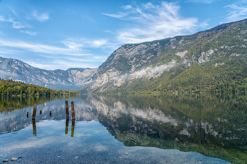 Morning view of Lake Bohinj with fog, mountain reflecting in tranquil lake water,  Julian Alps, Slovenia