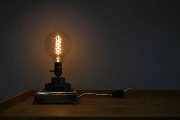 table lamp with a filament on the gears and wood base in steampunk style