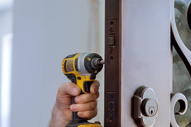 istock Locksmith hand holds the screwdriver in installing new house door lock 1278294437
