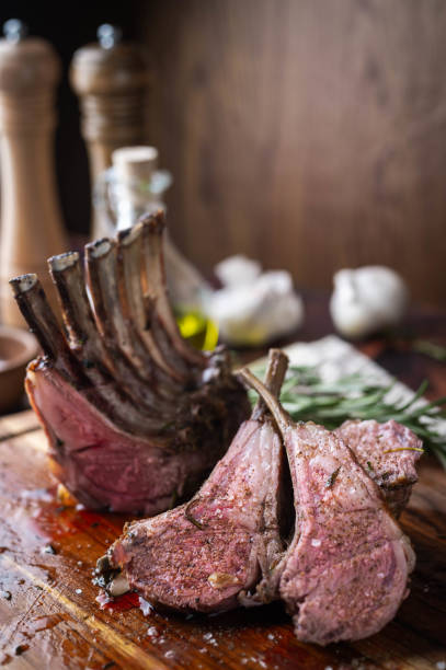 roasted lamb rack on wooden cutting board