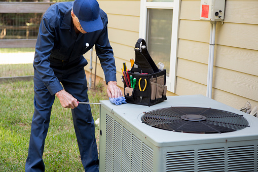 Senior Adult air conditioner Technician/Electrician  services outdoor unit.