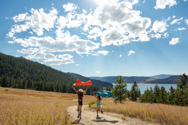 タオルを持ってビーチに走る女の子 - okanagan valley ストックフォトと画像