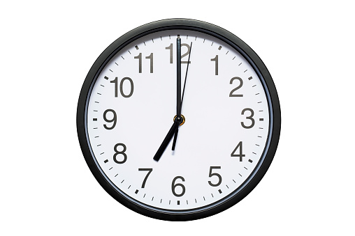 Wall clock shows time 7 o'clock on white isolated background. Round wall clock - front view. Nineteen o'clock