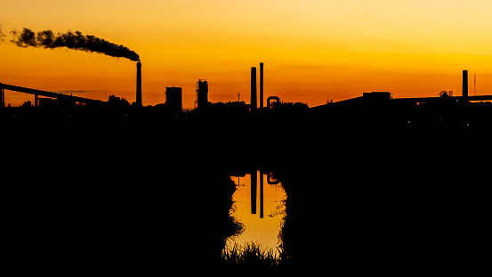 Industrial scene silhouette during sunset orange glow