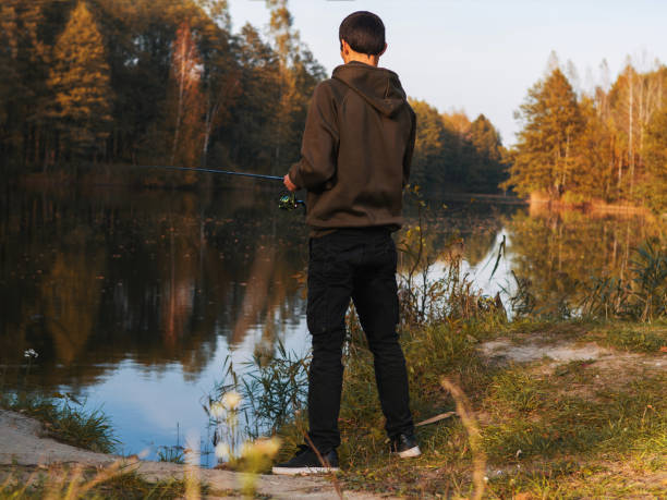 istock A man catches fish on a spinning rod in the fall on the lake 1278298613