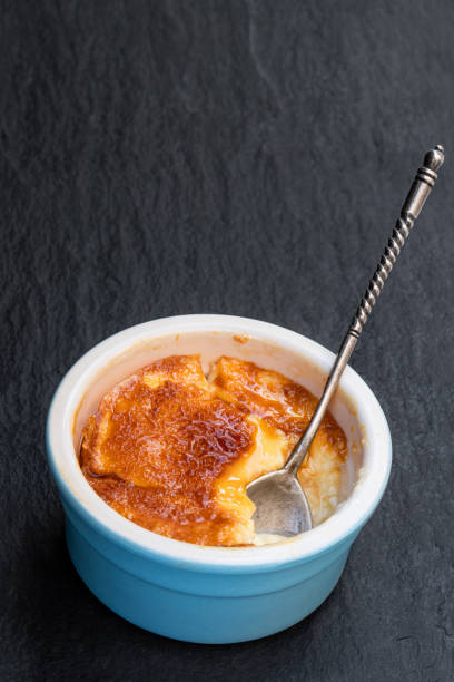 creme brulee em pote de porcelana azul no fundo de pedra preta - custard creme brulee french cuisine crema catalana - fotografias e filmes do acervo