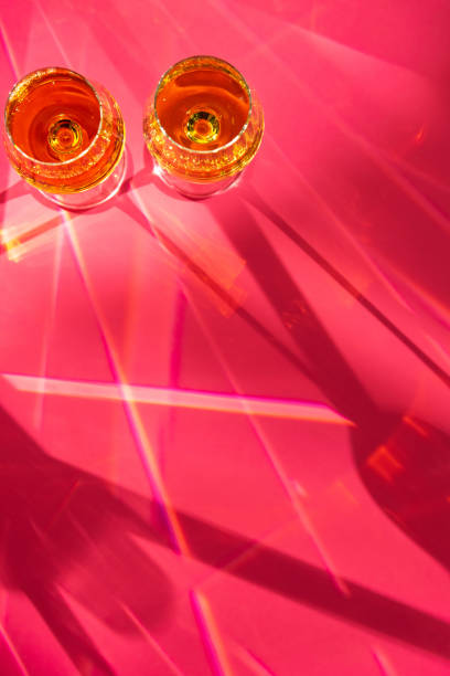 istock Glasses with champagne and light flecks on red background 1278302590