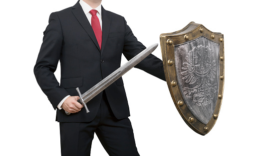 Businessman with sword and shield isolated on white background with clipping path. Business protection concept.