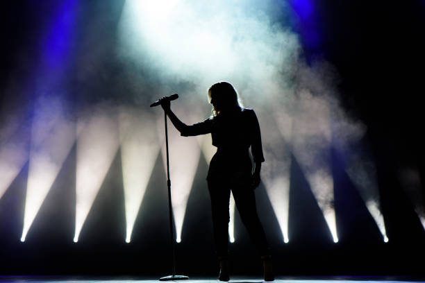 istock Vocalist singing to microphone. Singer in silhouette 1278304249