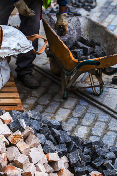 istock Construction work on pavement. Installation of concrete paver blocks on the sidewalk. The worker sorts the stone pavement. 1278305199