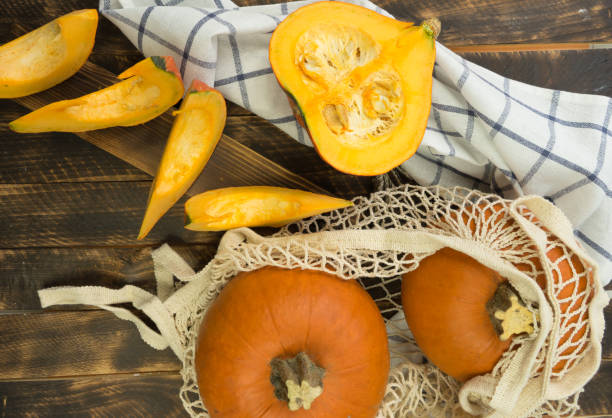 istock Pumpkin at the wooden table in the string bag shopper. 1278306184