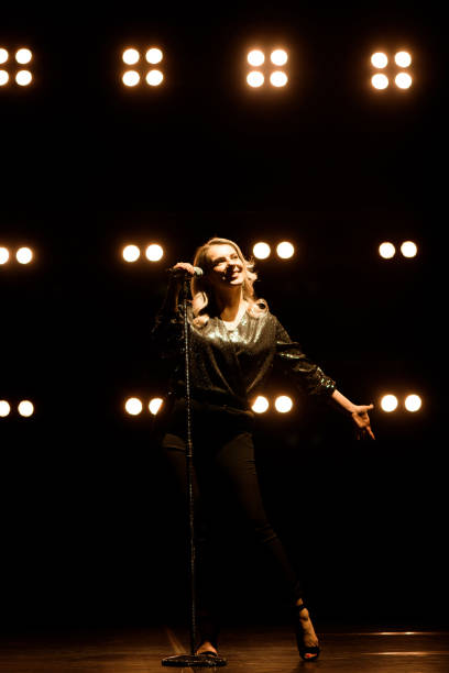 istock Vocalist singing to microphone. Singer in silhouette 1278308826