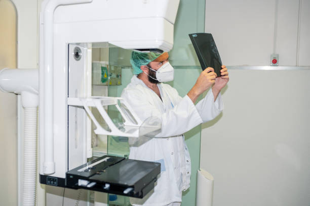 Doctor with mask checking mammography of woman in x-ray room. Doctor with mask checking mammography of woman in x-ray room. cancer screening stock pictures, royalty-free photos & images