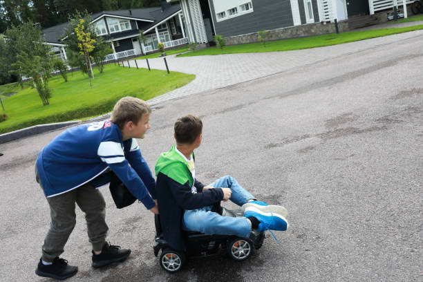 dziecko pcha samochodźą, na której siedzi jego przyjaciel - car child teamwork sports race zdjęcia i obrazy z banku zdjęć