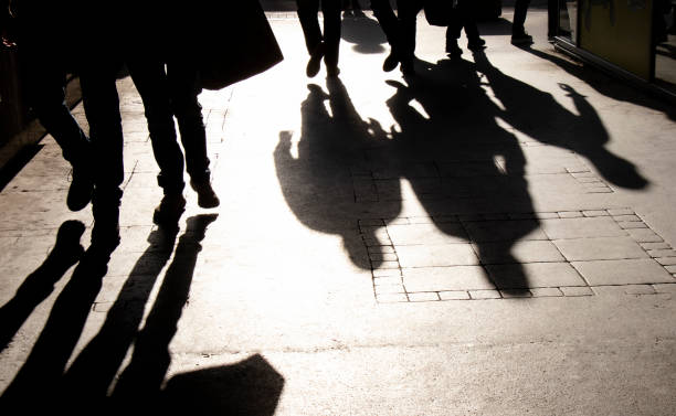 verschwommene schattensilhouette von menschen, die in schwarz und weiß in der fußgängerzone spazieren gehen - rush hour commuter shadow focus on shadow stock-fotos und bilder