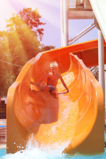 istock happy boy quickly going on orange water slide 1278315359