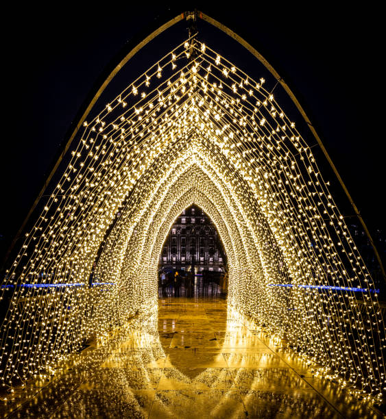 Street light Christmas decorations, large group of yellow and blue light circles in Vigo, Galicia, Spain.  Red tail lights in the lower part of the image. Copy space on the right.