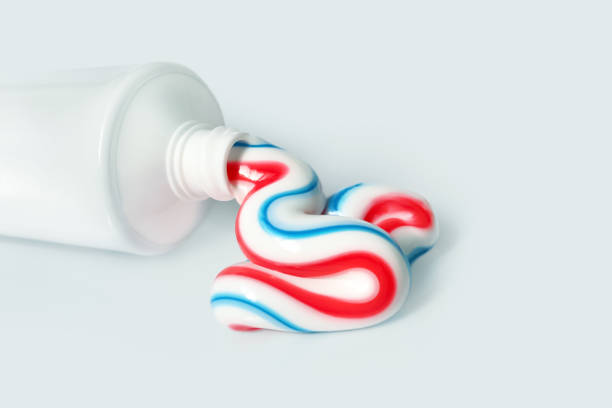 歯科衛生製品。トリカラー歯磨き粉、コピースペース。軽い背景に分離歯磨き粉と白いチューブ - 歯みがき ストックフォトと画像
