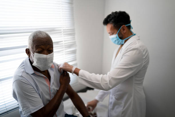 istock Nurse applying vaccine on patient's arm using face mask 1278324313
