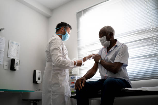 istock Nurse applying vaccine on patient's arm using face mask 1278325467