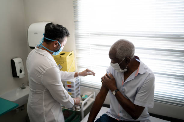 istock Nurse applying vaccine on patient's arm using face mask 1278325805