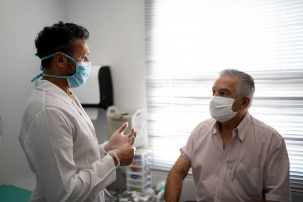 paciente en una consulta médica usando mascarilla facial - 50s adult doctor equipment fotografías e imágenes de stock