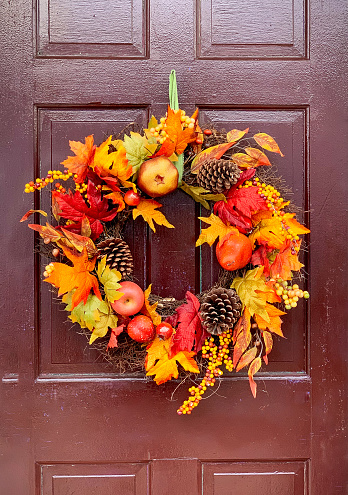 Autumn fall wreath decorations on brown vintage wooden door. Outdoor seasonal decor