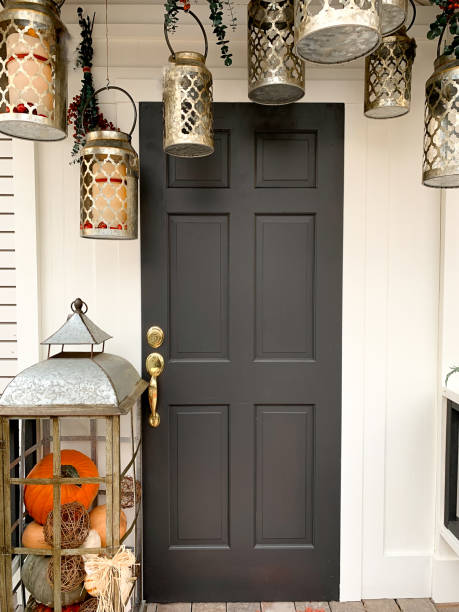 Fall seasonal decorations on porch and front door. Vertical autumn house decorated for Autumn