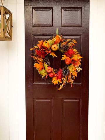 Autumn fall wreath decorations on brown vintage wooden door. Outdoor seasonal decor
