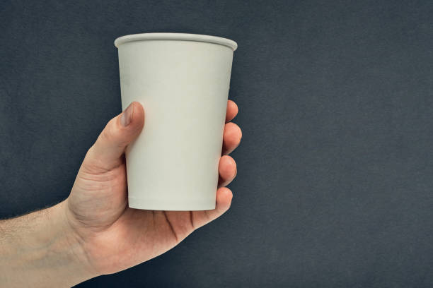 istock Paper cup in hand on a colored background. Eco-friendly materials in a coffee shop, biodegradable disposable tableware. Close up 1278329882
